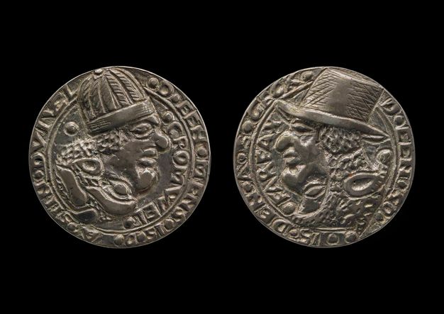 Medal. Both sides show profile portraits of men, both with exaggerated, bulbous features. The man on the recto, to our left, wears a rounded cap. The other, to our right, a brimmed hat. Text is around the perimeter of each.