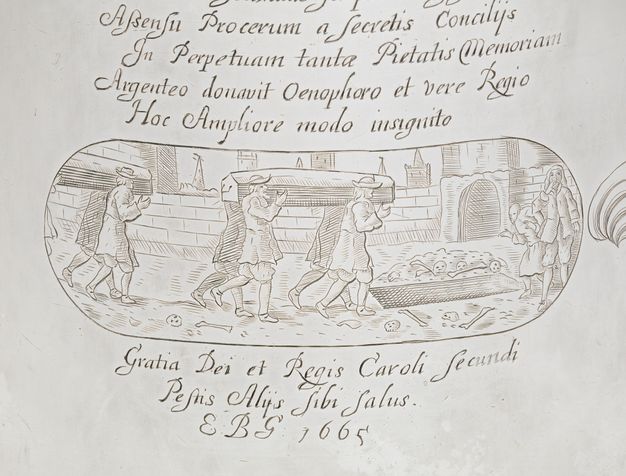 Tankard. Detail view of an oval shaped cartouche and text incised on its surface. In the cartouche, four men carry a casket on their shoulders as they walk towards an open grave surrounded by skulls and bones. Another foursome follows behind them.